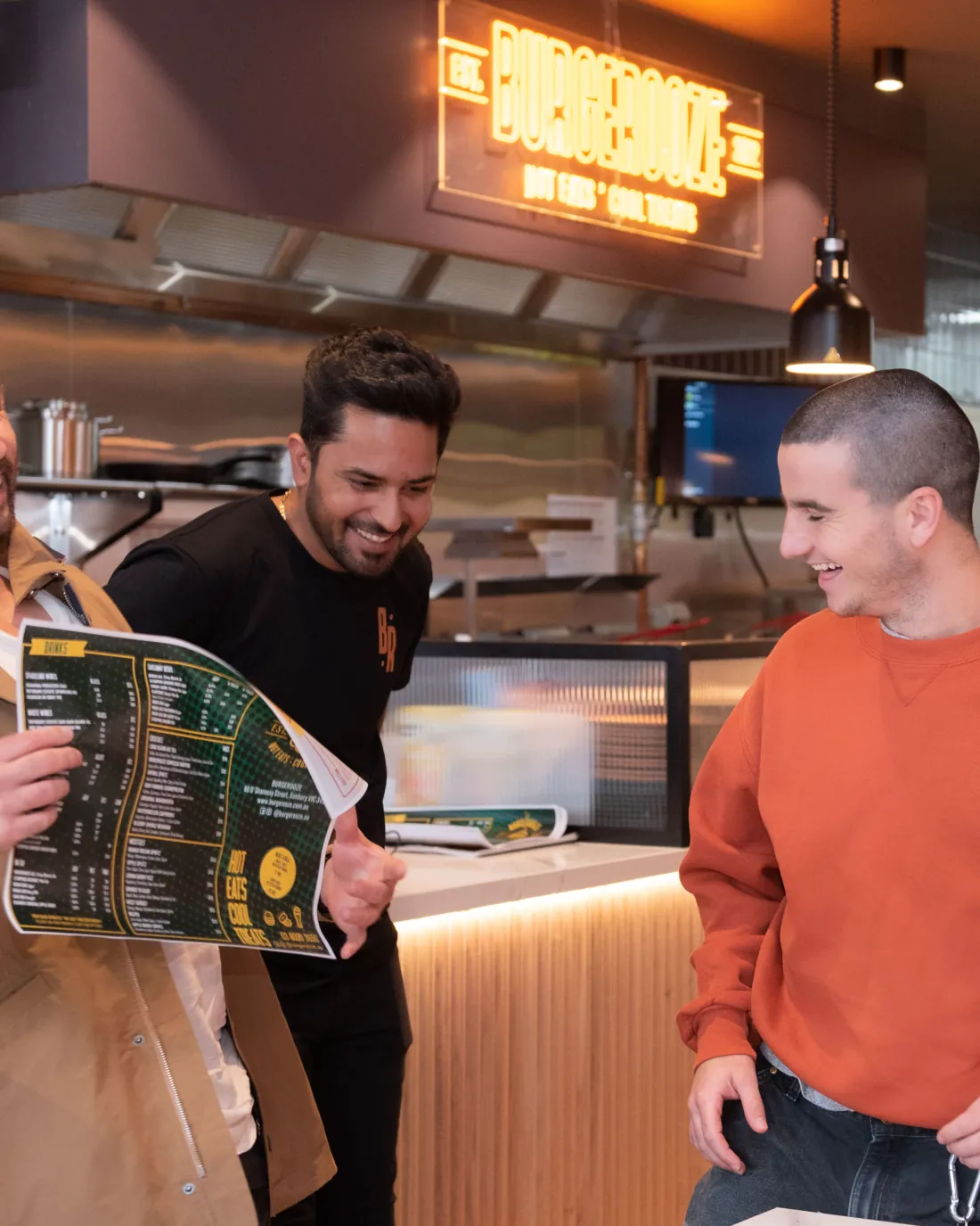 Friends laughing over the menu at the counter